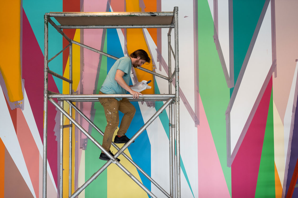 Conor Fields works on a mural