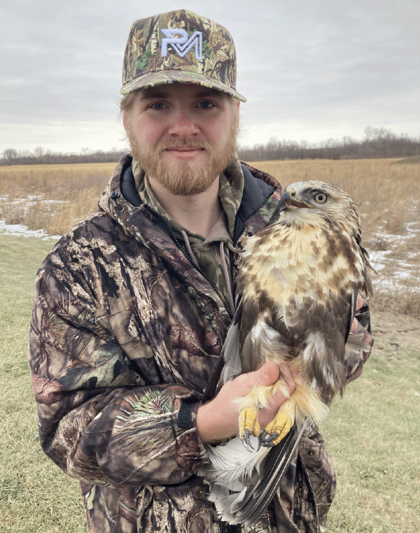 Aaron Petrie holds a rough-legged hawk