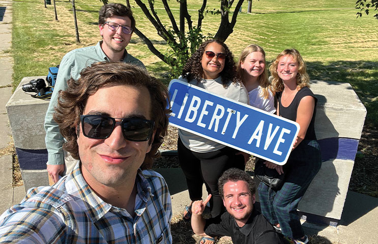 Students holding Liberty Ave Sign