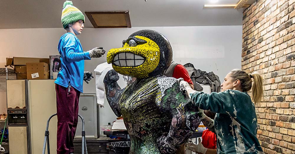 Artist Kelsi Lynch and family working on Herky