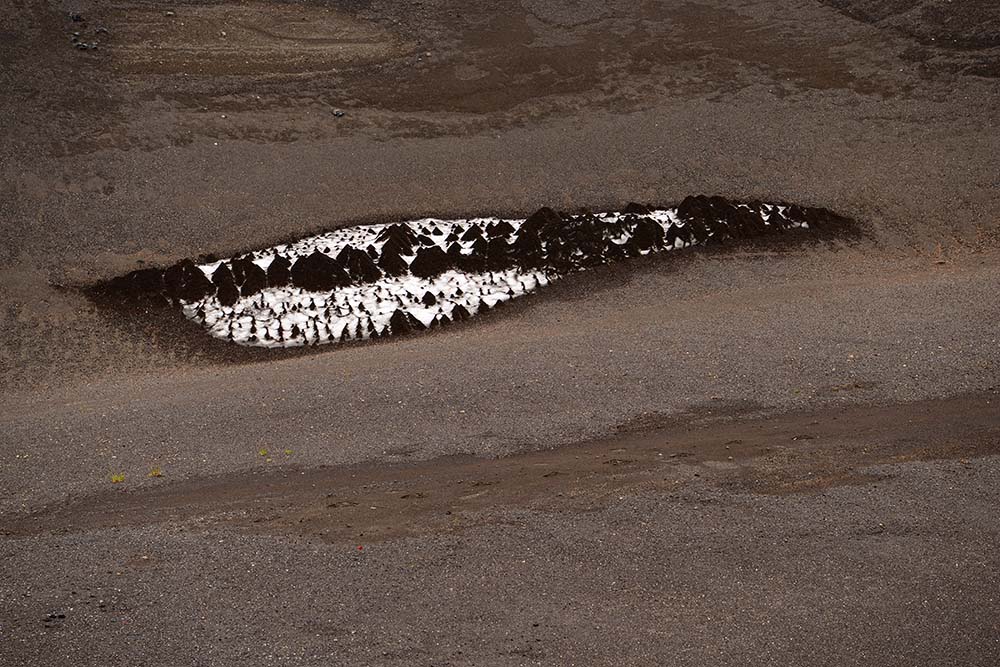 Small snowfield with conical pyramids of pumice covered snow