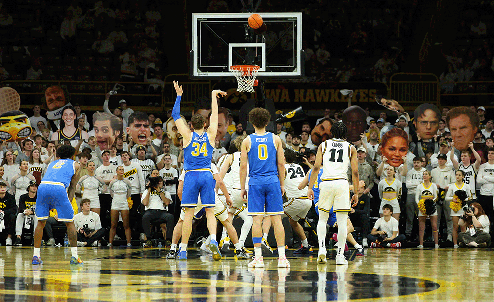 Fans holding cutout heads at game