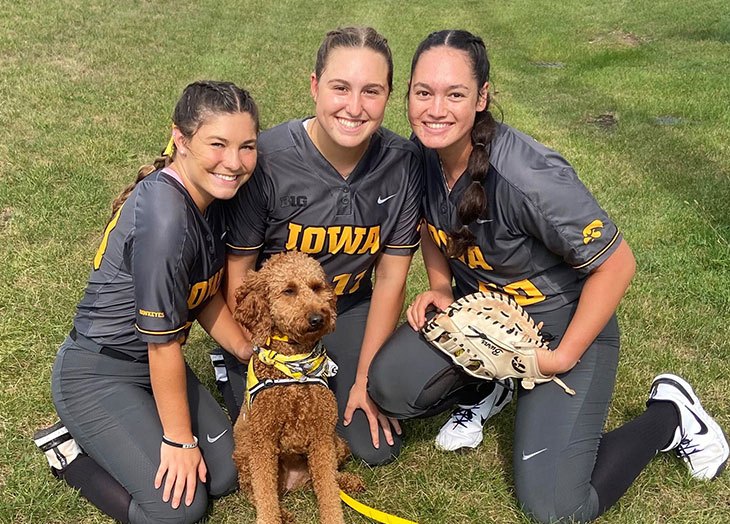 Image of softball players and dog